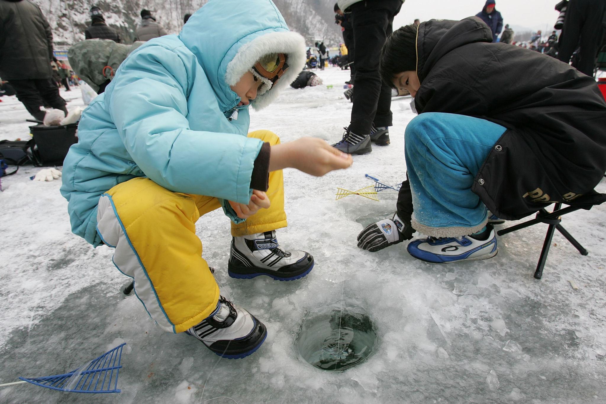 Visitors ice fishing at the Hwacheon Sancheoneo Ice Festival in Korea. kids.jpeg